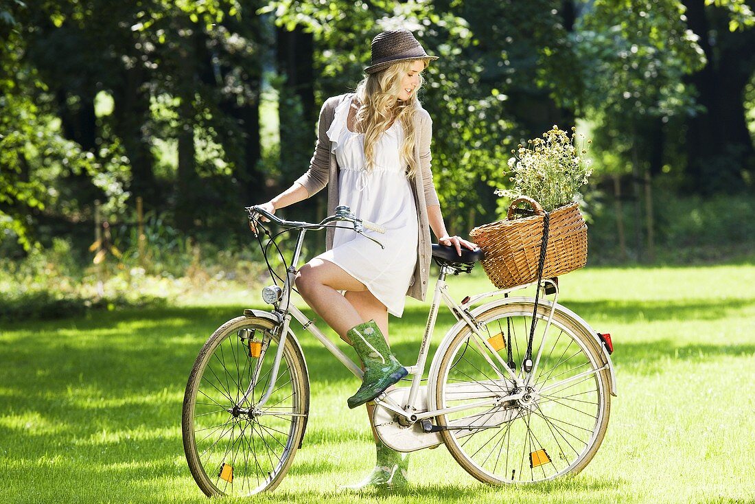 Blonde Frau mit Fahrrad im Park