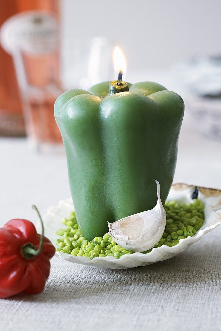 A pepper-shaped candle on a scallop shell dish as table decoration