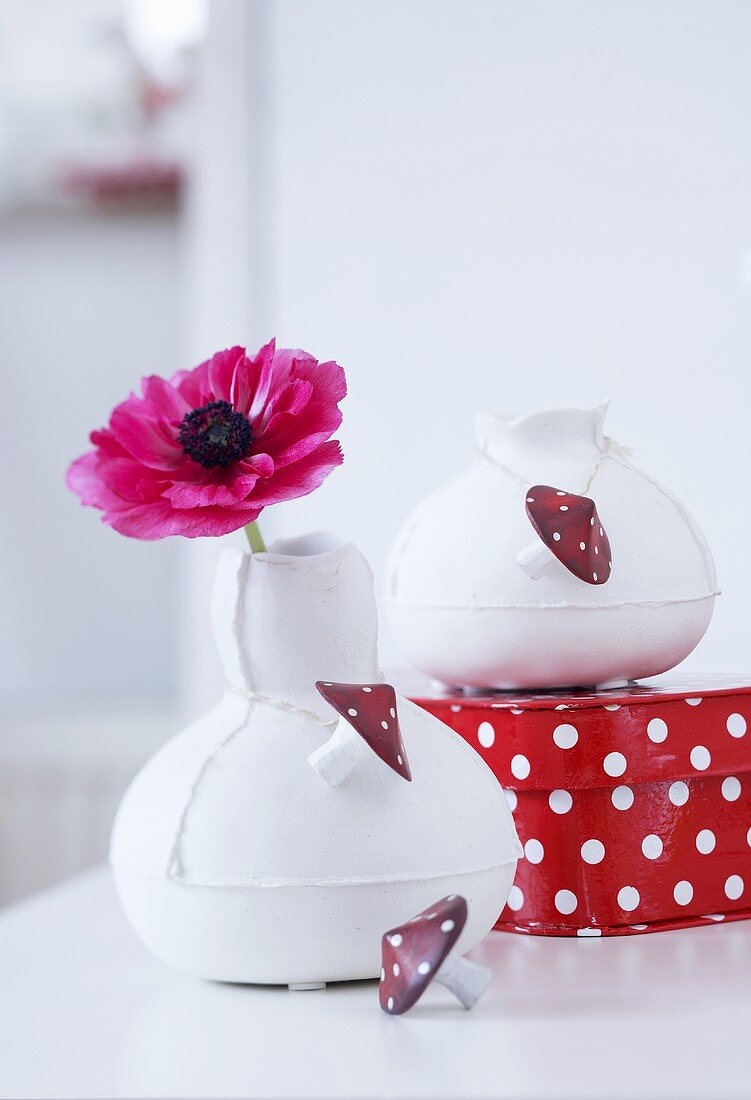 Vasen mit Fliegenpilz-Knöpfen dekoriert