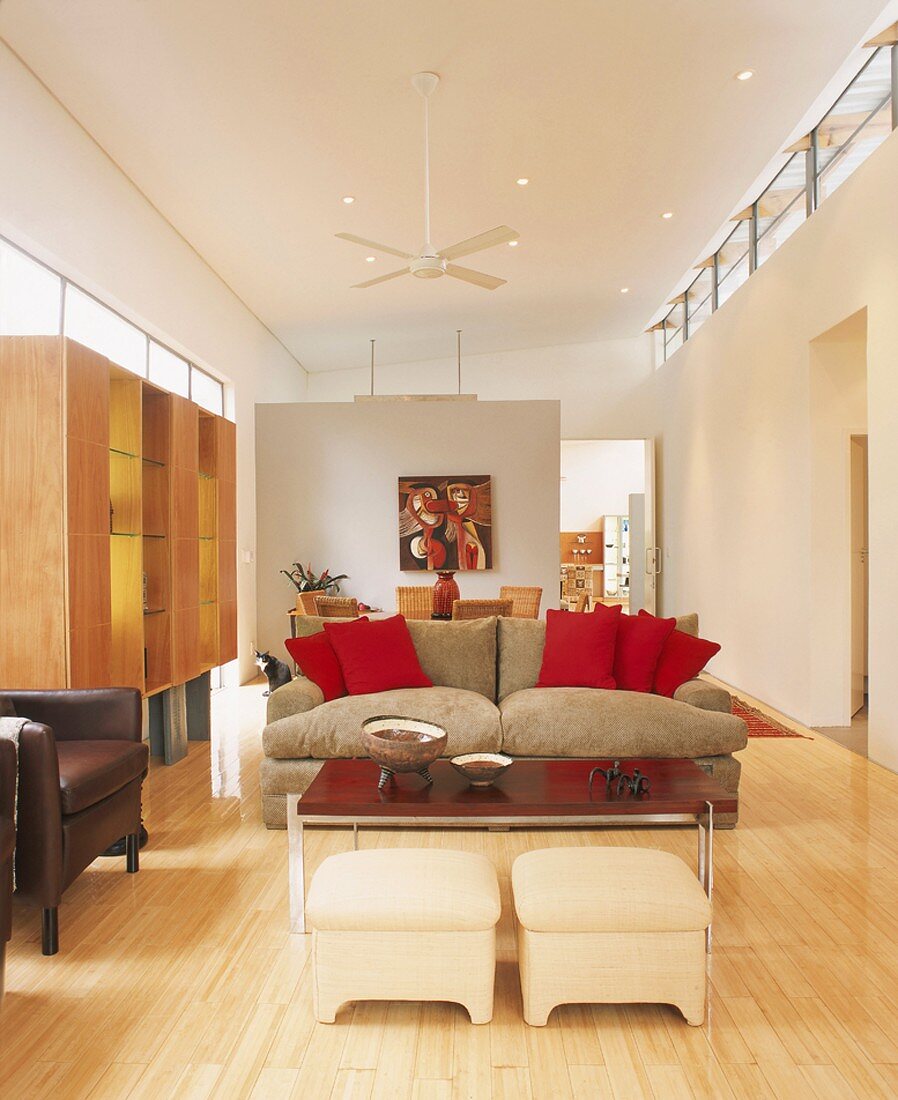 Offener länglicher Wohnraum mit Sofa, Wandschrank, Esstisch & Trennwand
