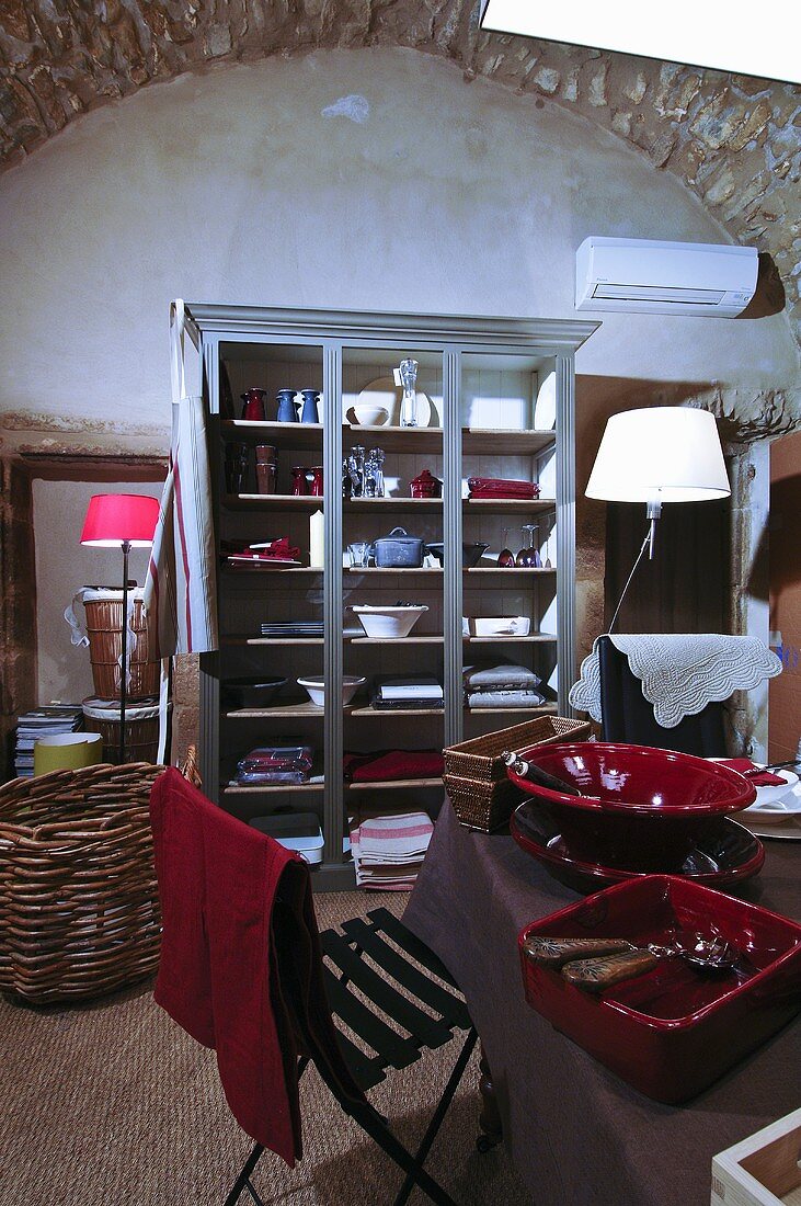 Vitrinenschrank mit Geschirr & Tischwäsche in Raum mit Rundbogendecke