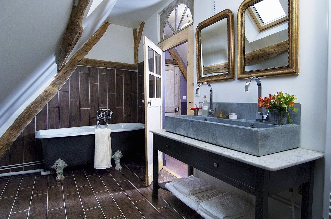 Badezimmer unter Dachschräge mit freistehender Badewanne, länglichem Waschtisch & zwei Spiegeln