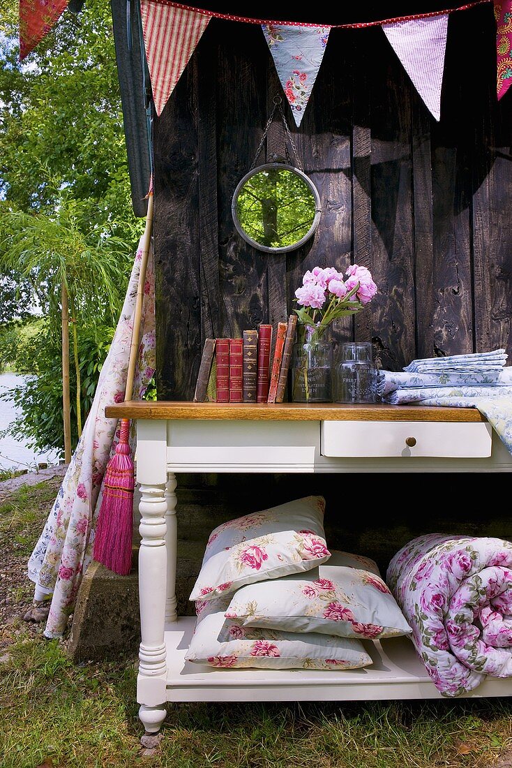 Books and garden cushions on table out of doors
