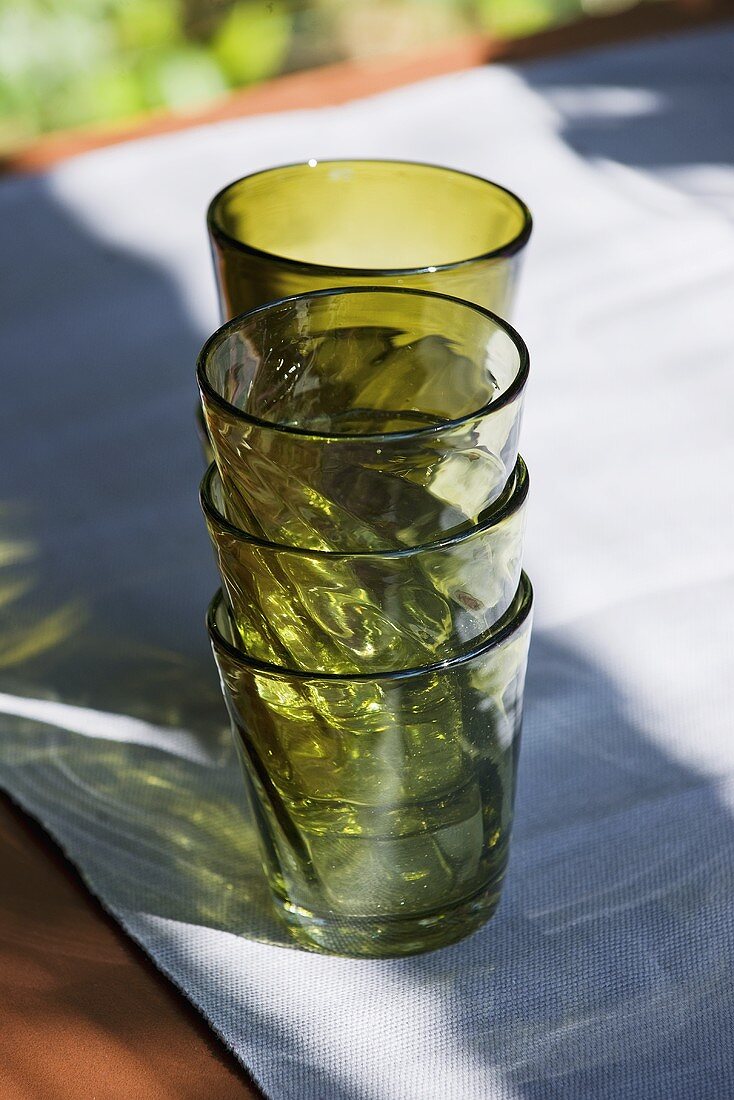 Grüne Trinkgläser, gestapelt, auf Tisch im Freien