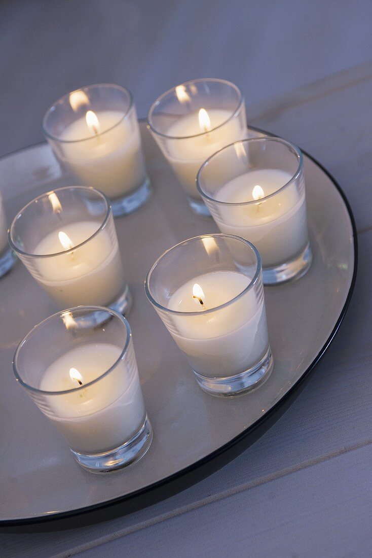 Several candles in glasses on plate