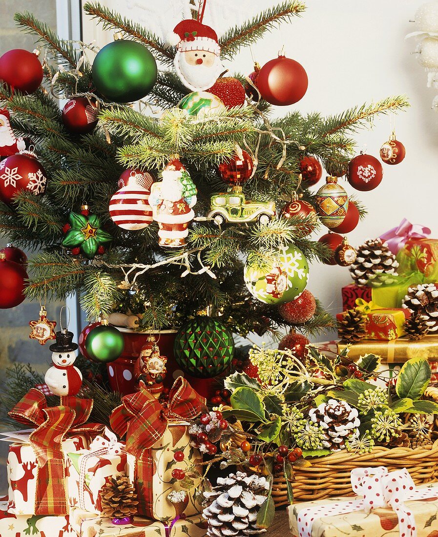 Geschenke unter bunt geschmücktem kleinen Weihnachtsbaum