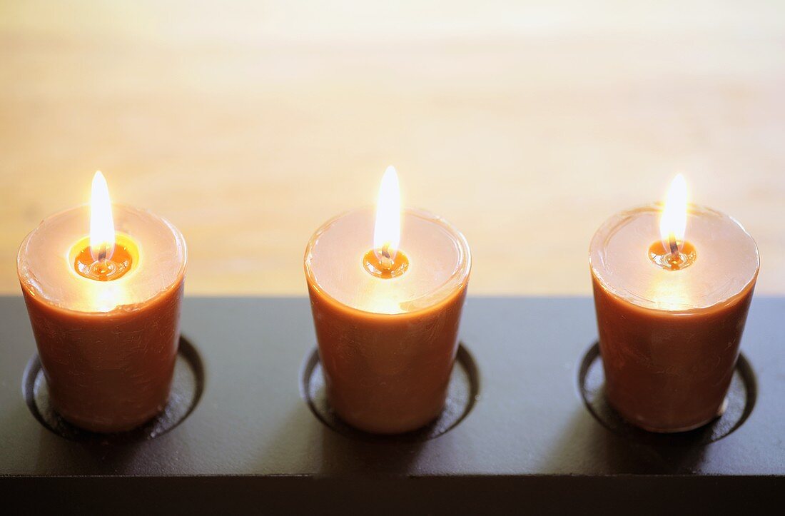 Flacher Kerzenhalter mit drei brennenden Kerzen