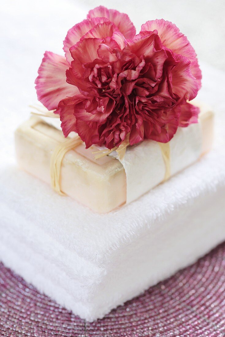 Towel, soap and a carnation (Dianthus caryophyllus)
