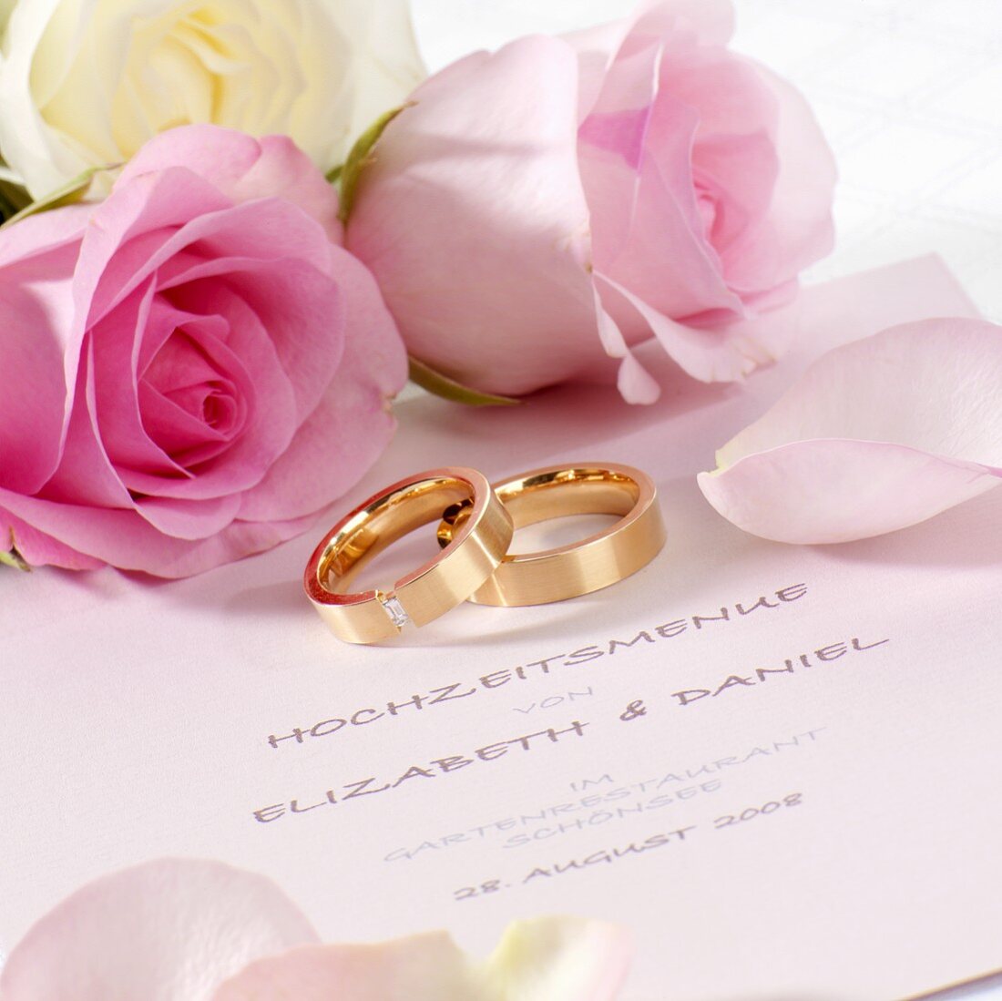 Hochzeitsmenükarte, Trauringe und rosa Rosen