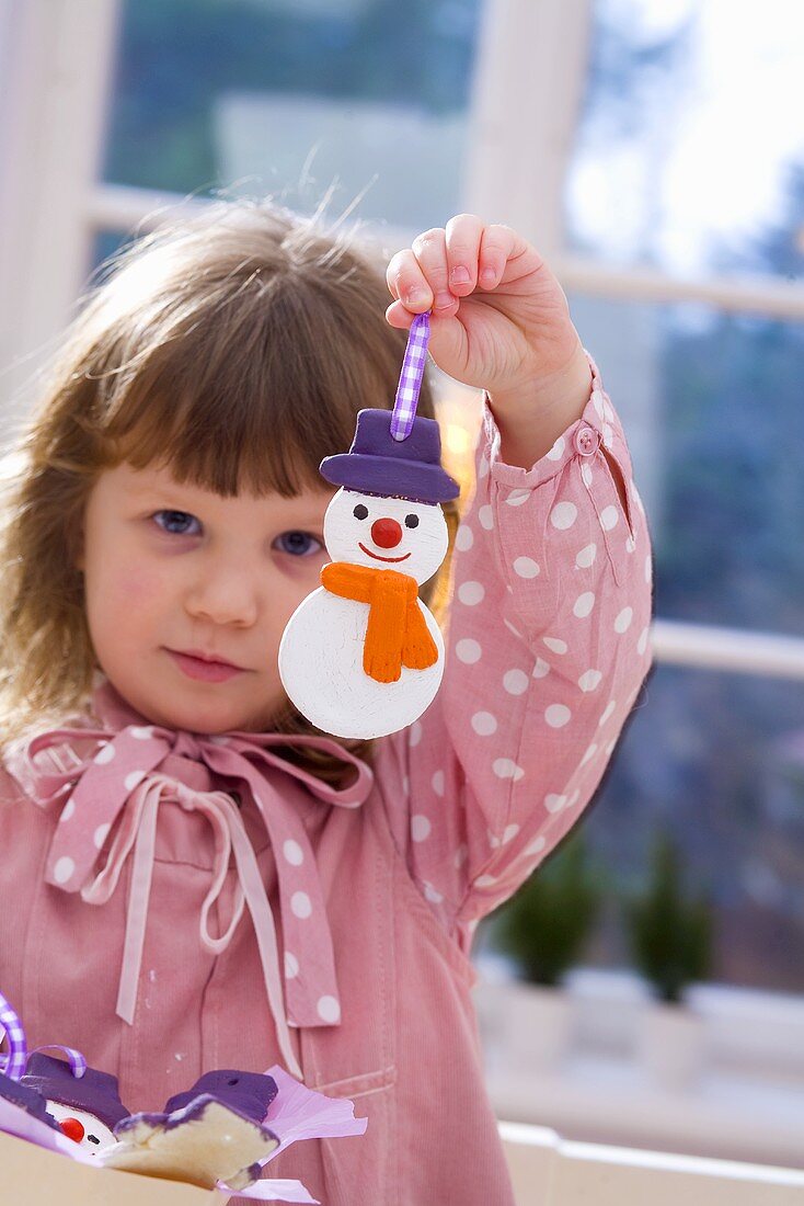 Girl holding salt dough snowman (tree ornament)