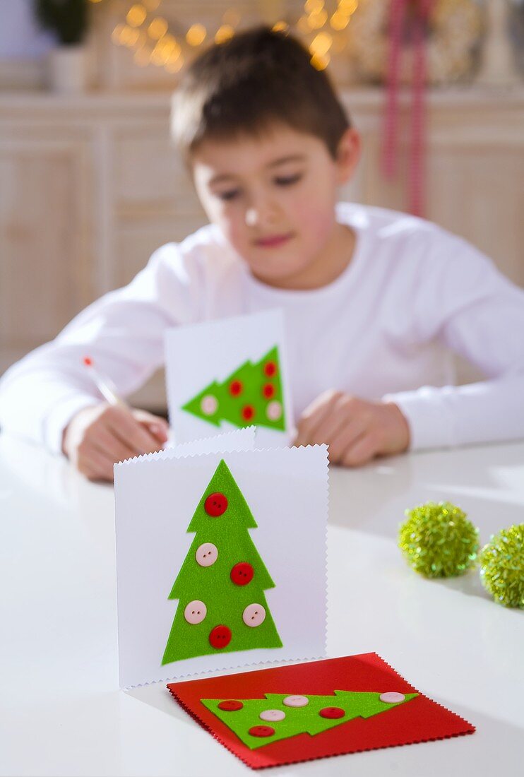 Junge schreibt Weihnachtskarten