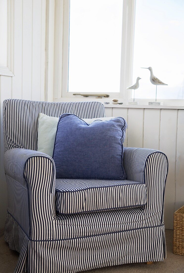 Blue striped chair in a room with a nautical theme