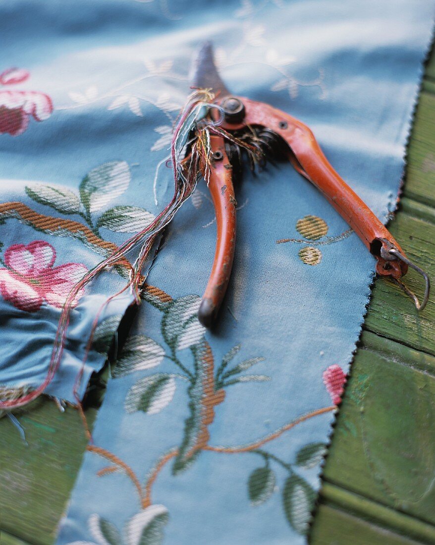 Blue fabric with floral pattern and secateurs