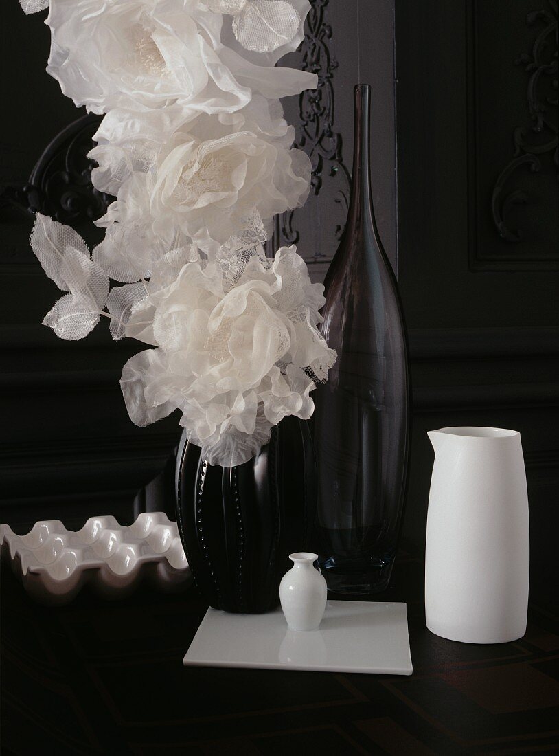 weiße Tüllblumen in schwarzer Vase