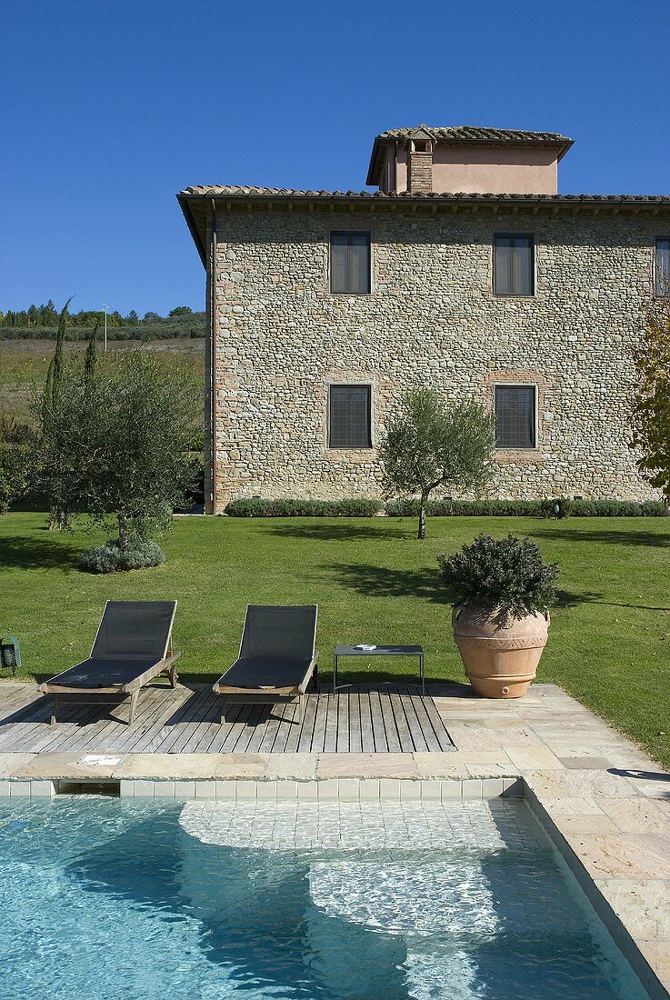 Pool mit Liegestühlen im Garten eines Mediterraner Landhauses