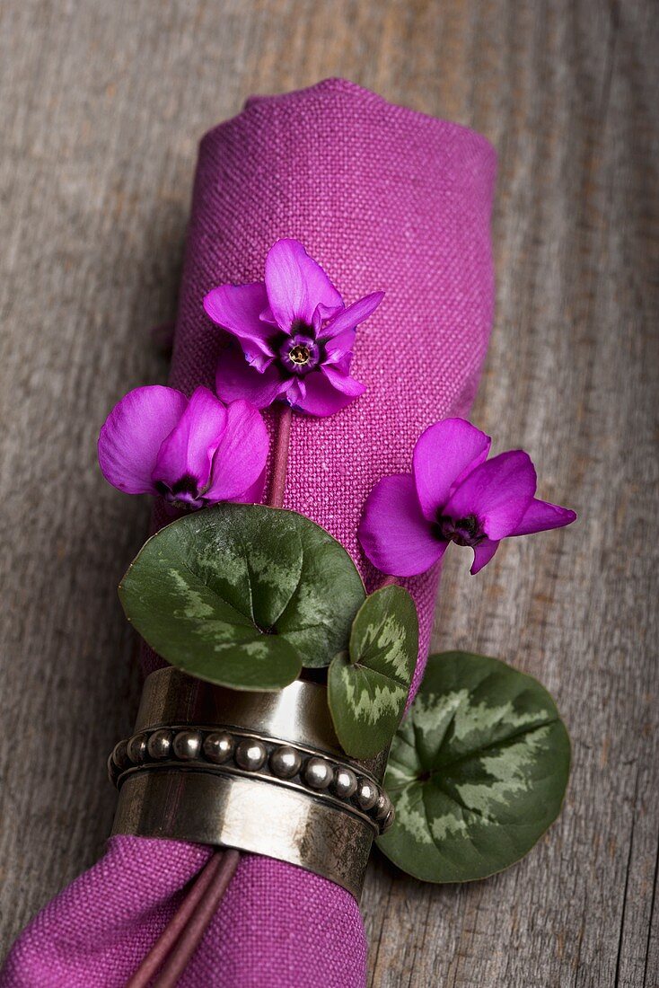A napkin decorated with flowers and leaves (Cyclamen coum)