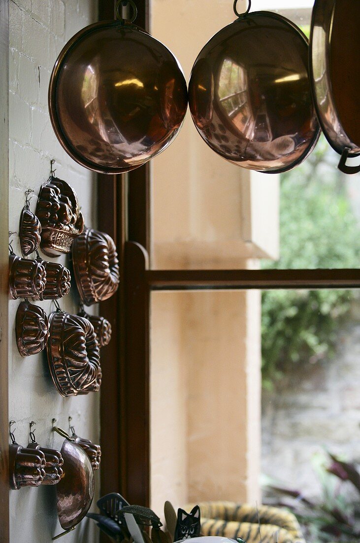 Kupferschüsseln und Kuchenformen in Küche