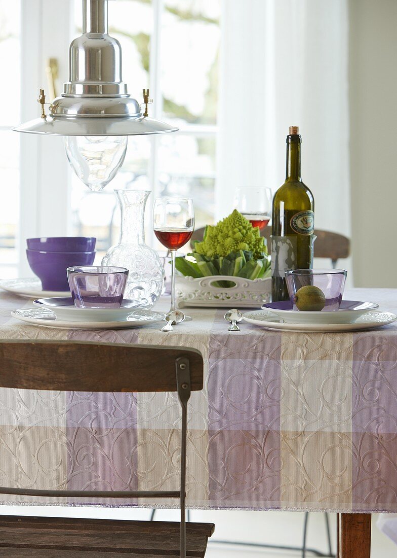 Gedeckter Tisch mit Rotwein und Romanesco