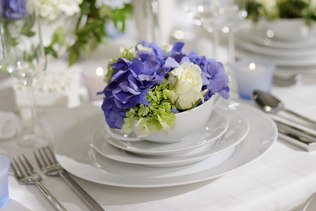 Festive place-setting for wedding with flowers in soup bowl