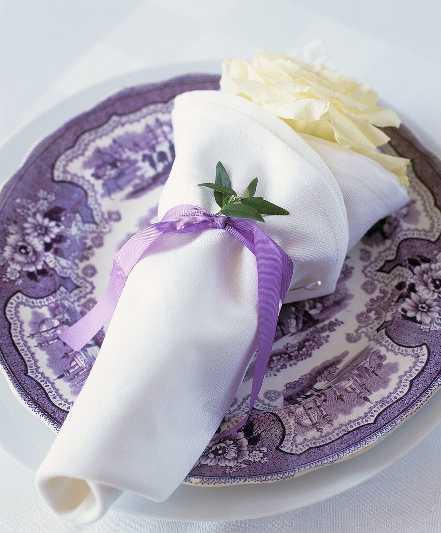 Fabric napkin with white rose and purple ribbon