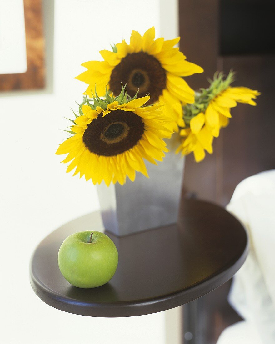 Still life with sunflowers and a green apple