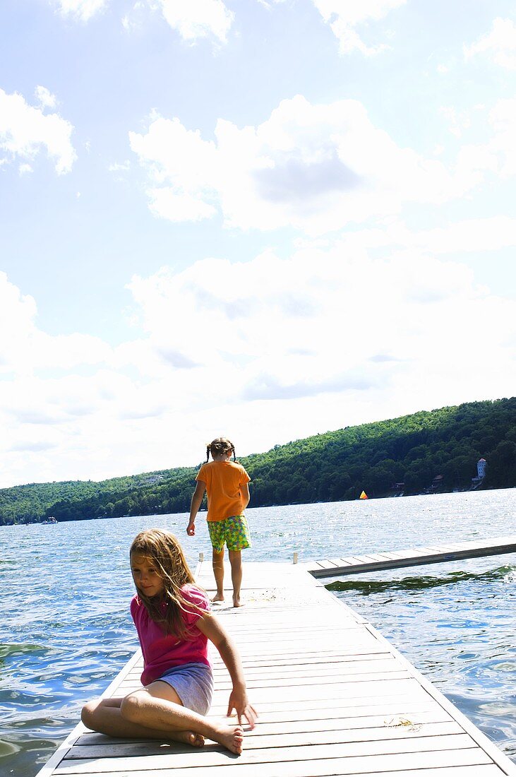 Zwei Mädchen auf einem Steg am See