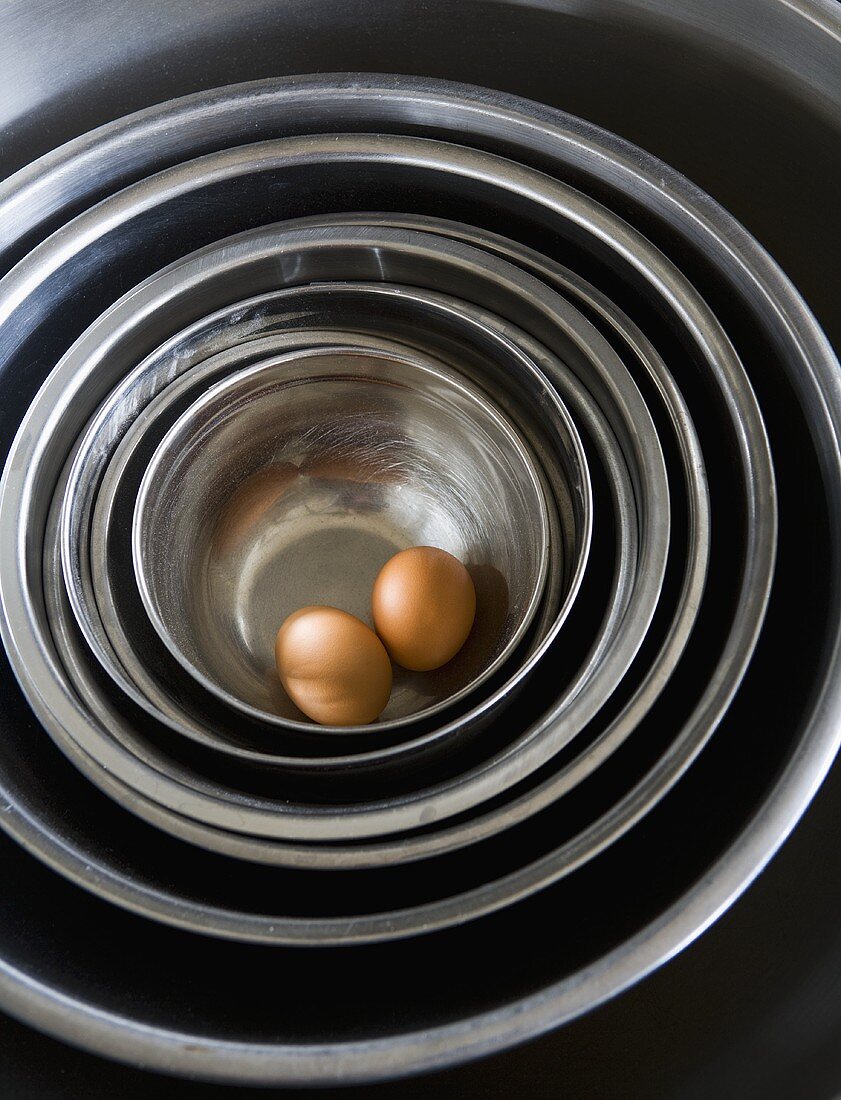 Zwei Eier in gestapelten Edelstahlschüsseln