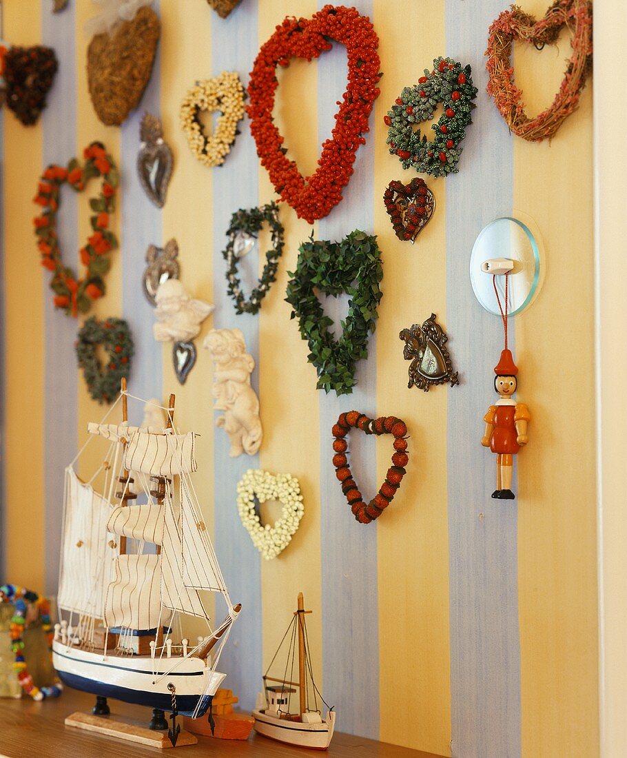 Various wreaths on the wall with a model sail boat