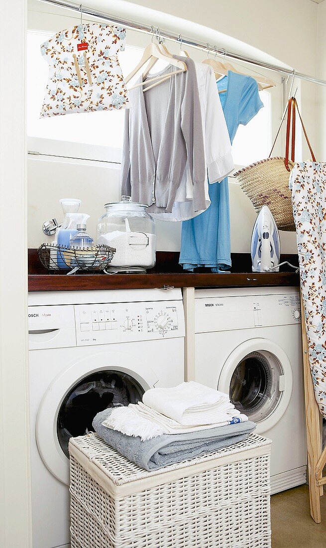 Kleidungsstücke und Wäsche in einem Kellerraum mit Waschmaschinen