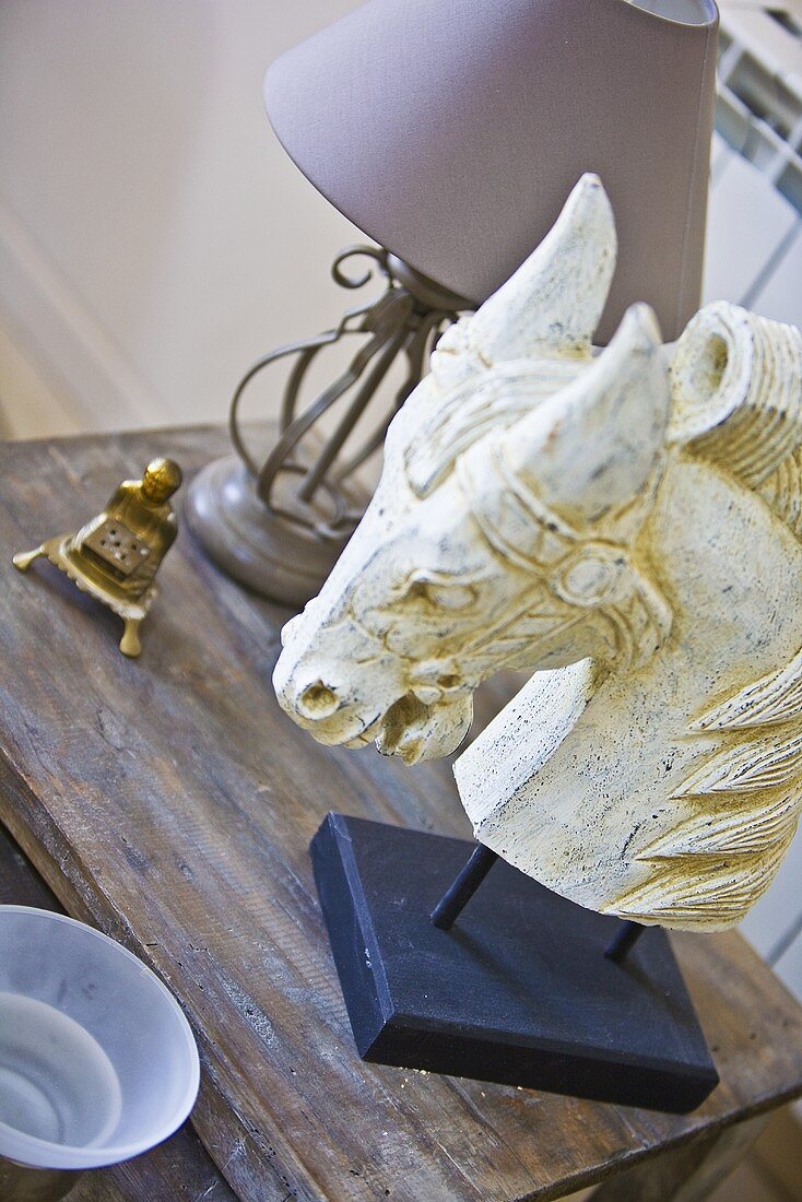 A carved white horse's head on a wooden table