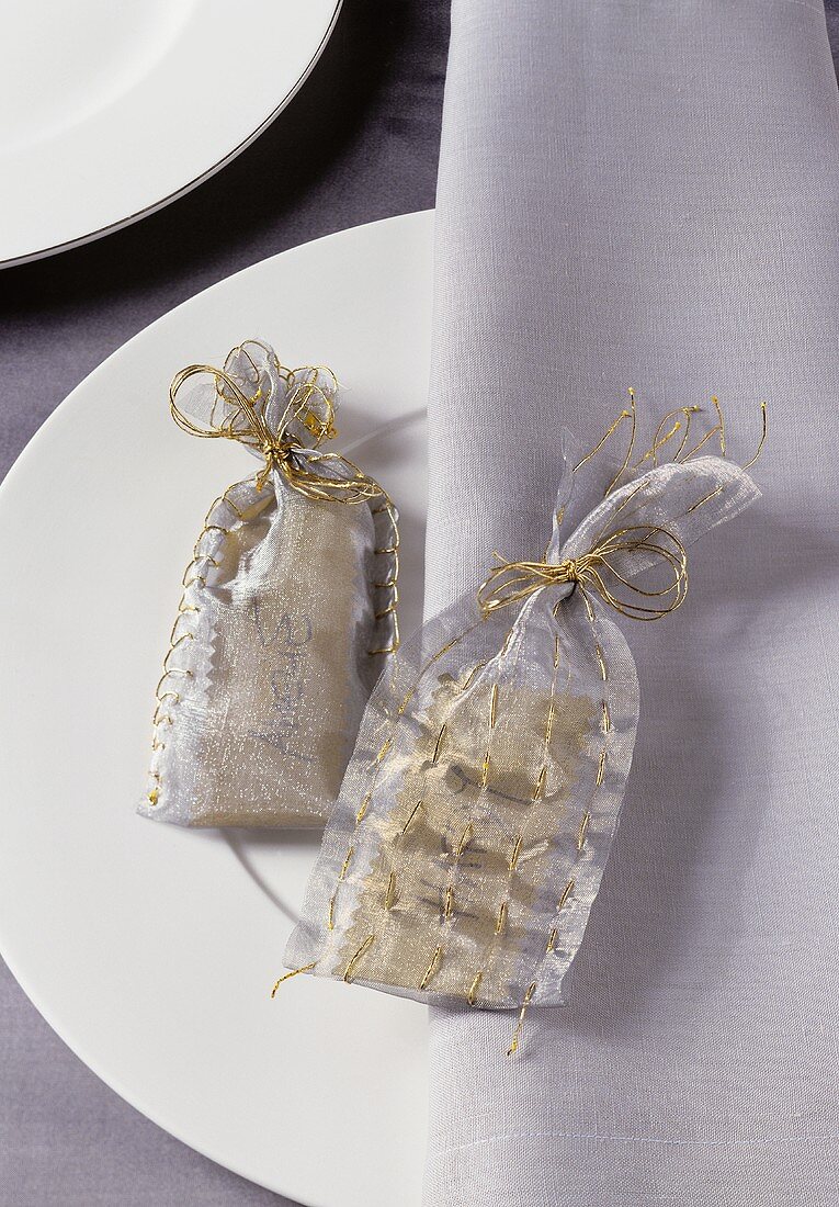 Christmas gift bags on a white place setting