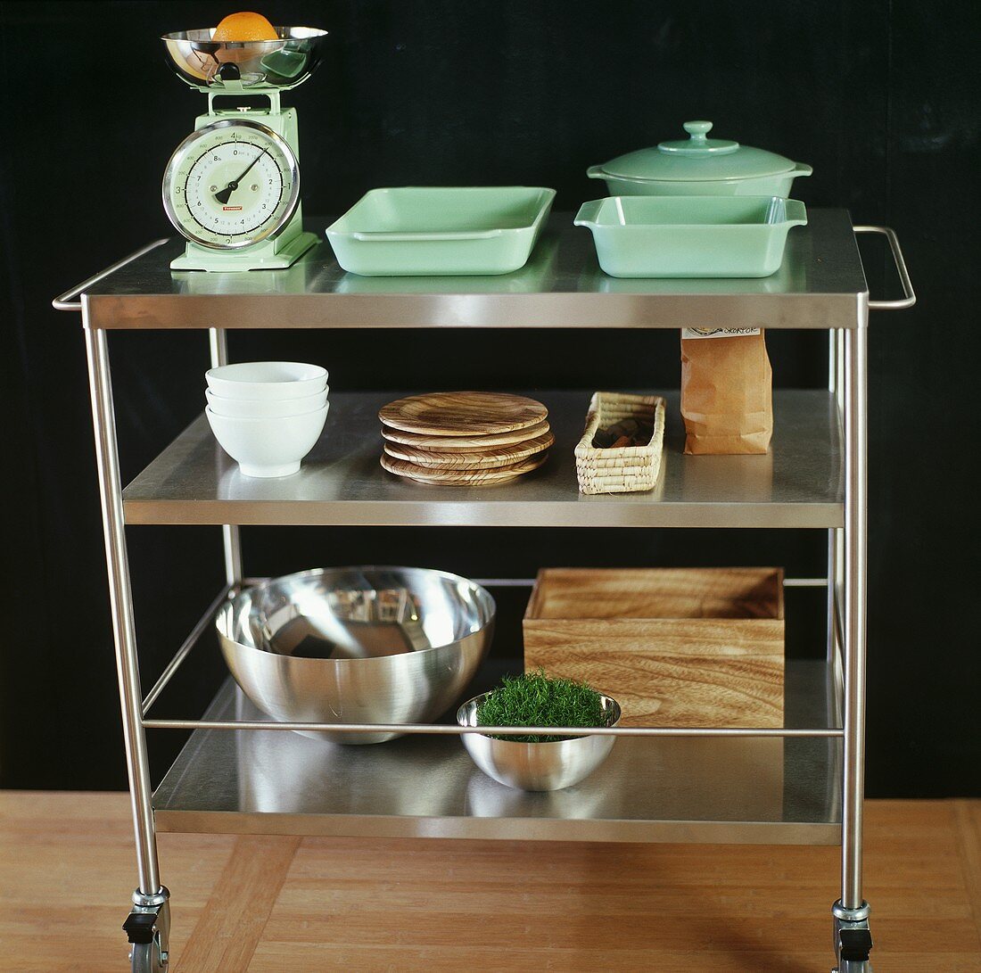 A tea trolley with stacked crockery and a pair of kitchen scales