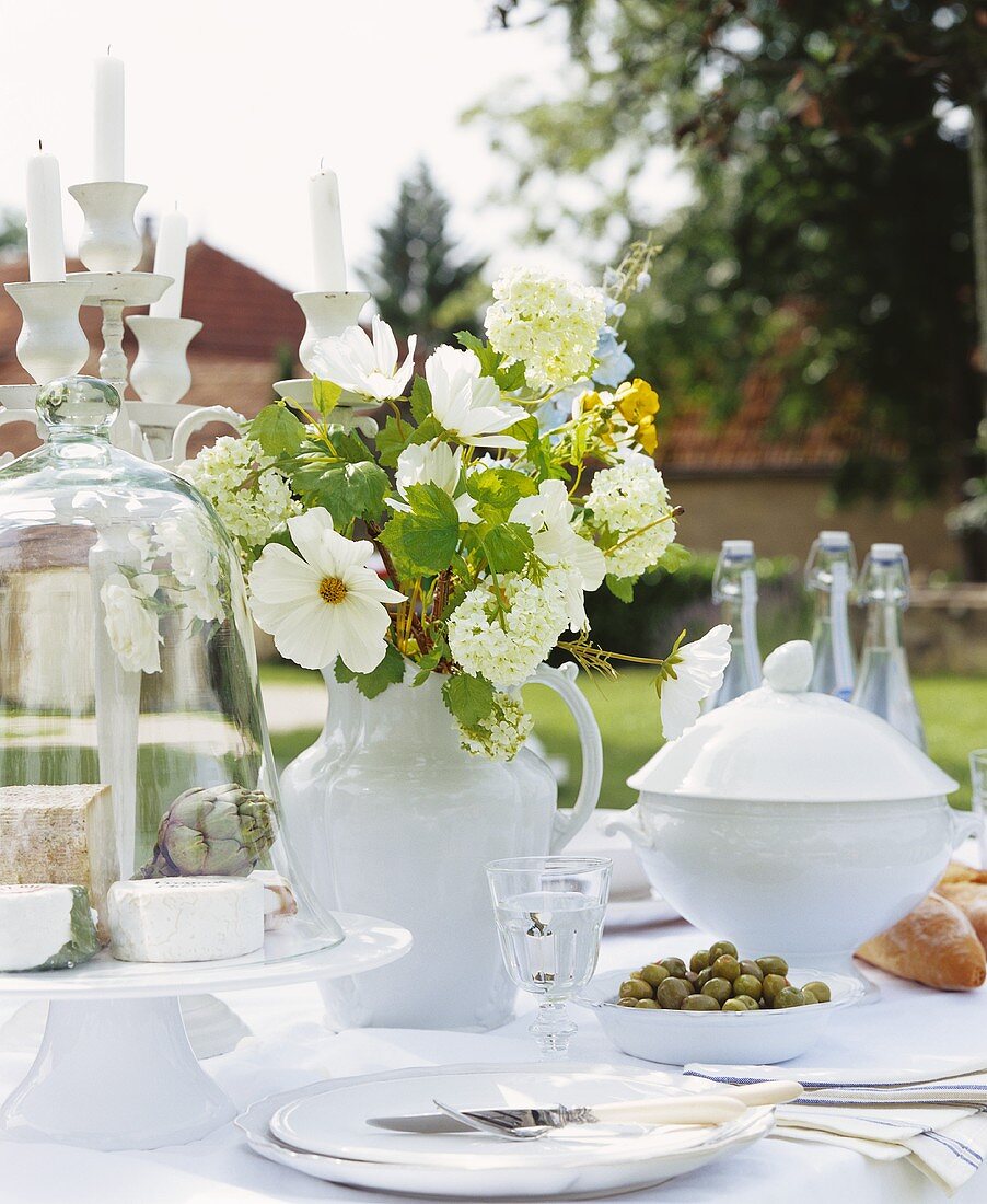 A bunch of white flowers on a table laid in a garden