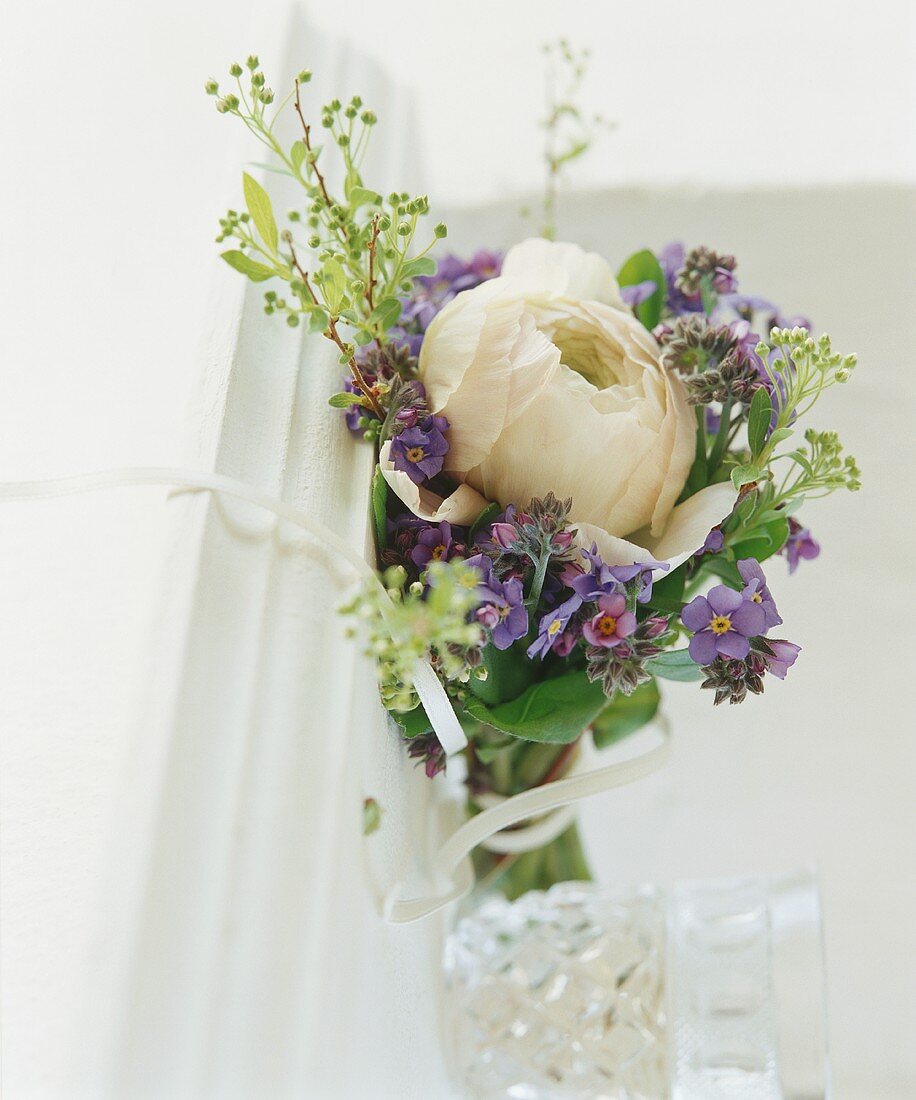 A bouquet made up of purple flowers and a large white flower