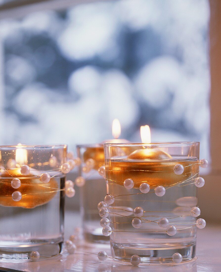 Floating candles in glasses decorated with beads