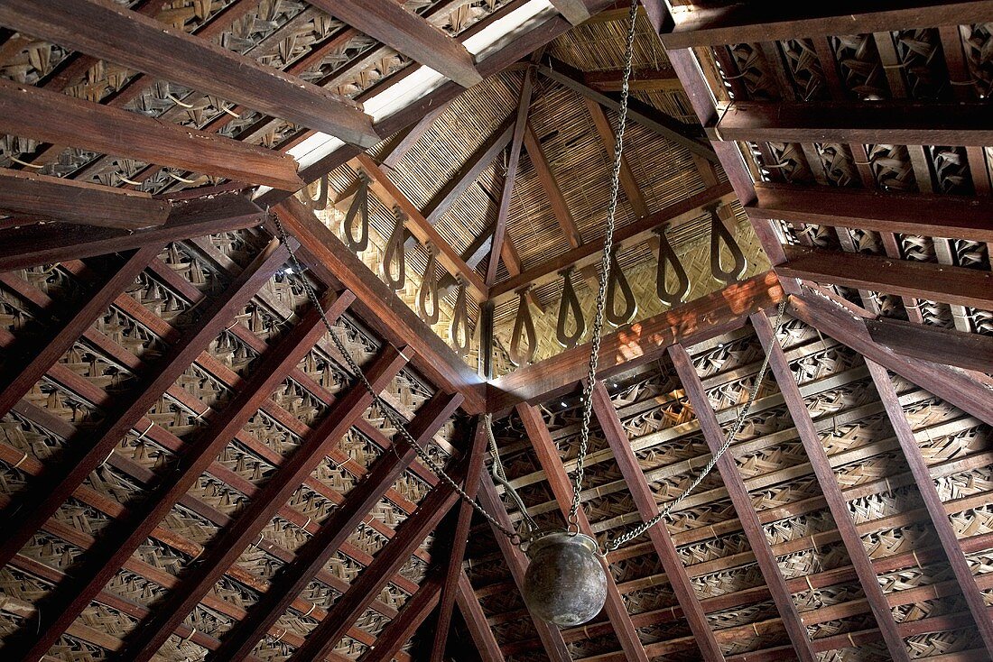 Indische Holzdecke mit abgesetztem Dach und hängendem Metallgefäss