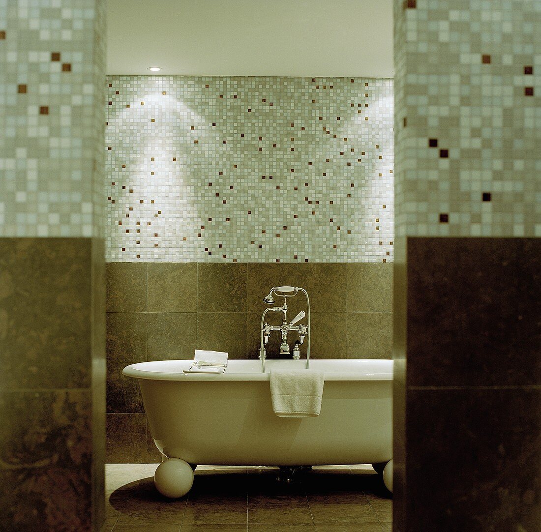 Freistehende Badewanne im Vintagelook vor Mosaikfliesen