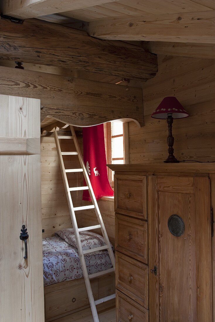 A bunk bed in a wood panelled attic room