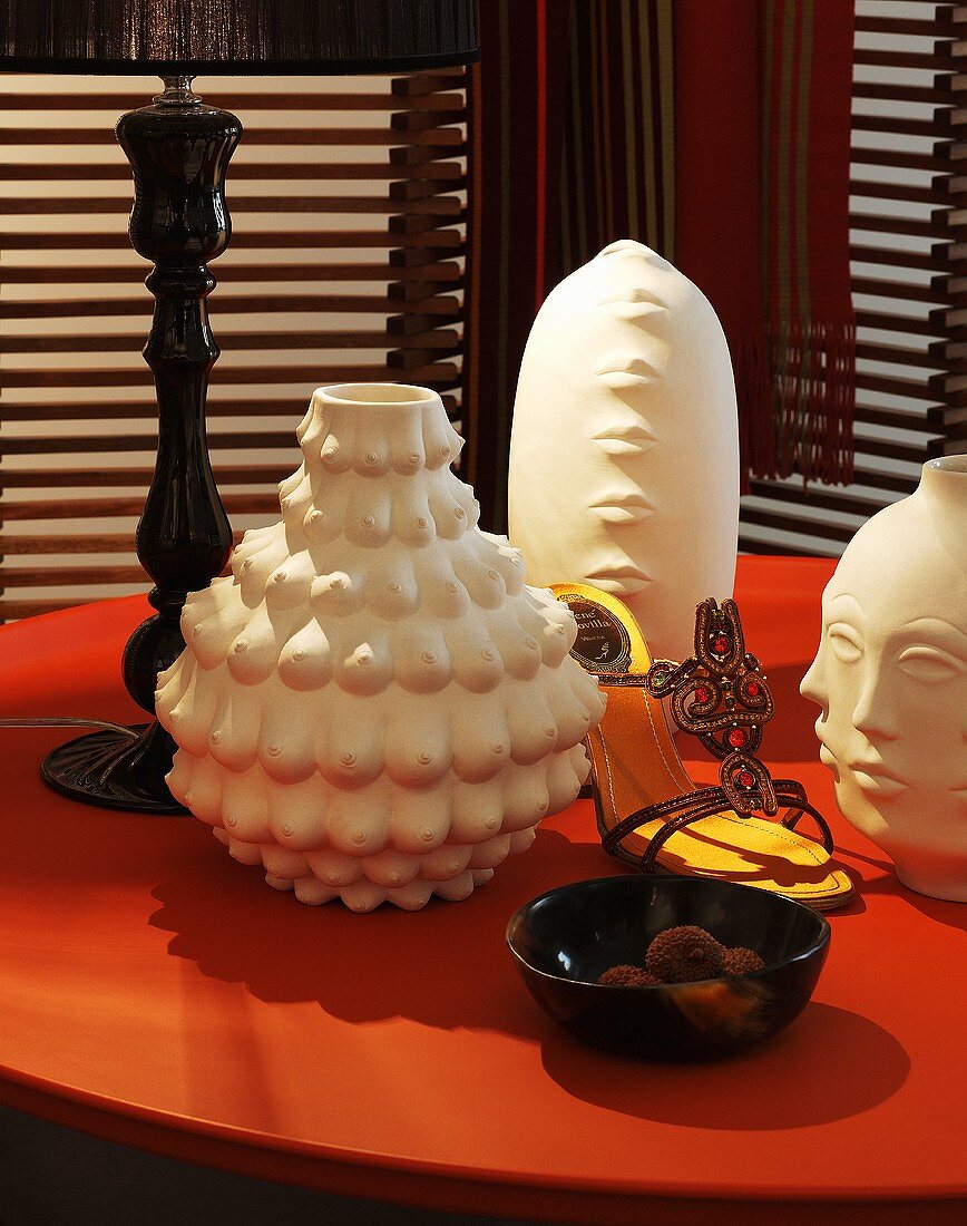 Künstlerische Vasen mit verschiedenen Motiven auf rotem Tisch