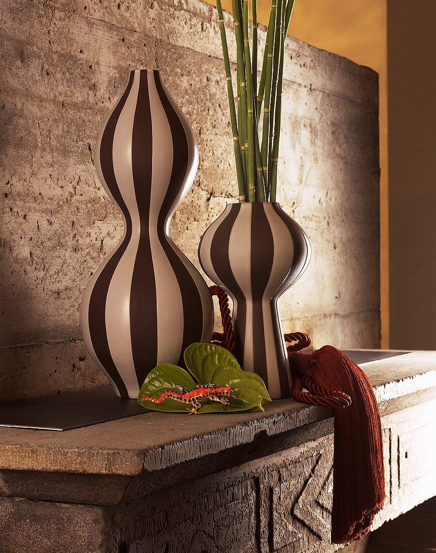 Stillleben - schwarz-weiss gestreifte Vasen auf Betonmöbel mit Rückwand