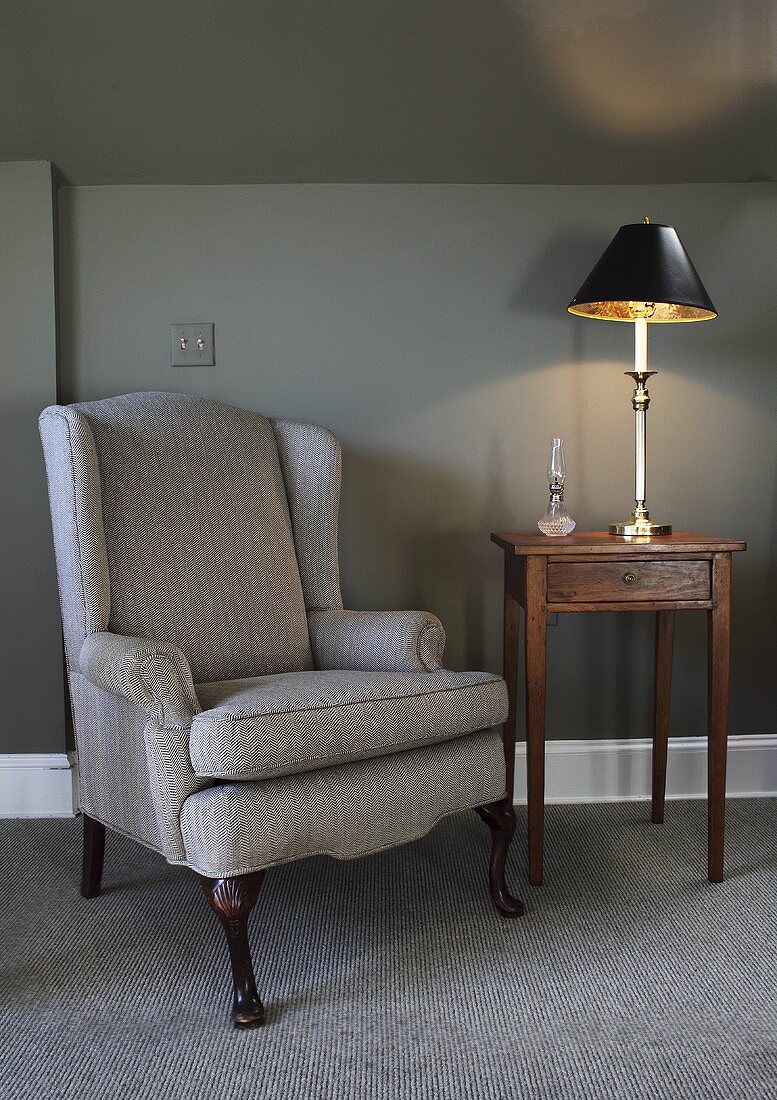 An armchair and a side table with a lamp