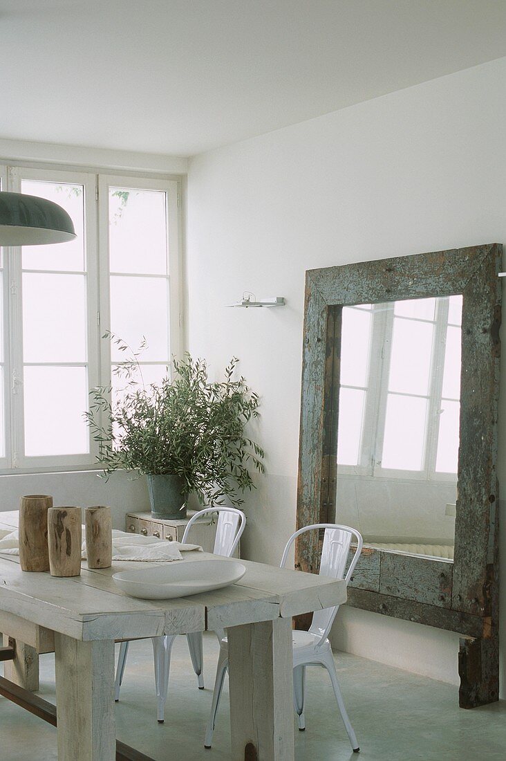 A wooden dining table in front of a mirror