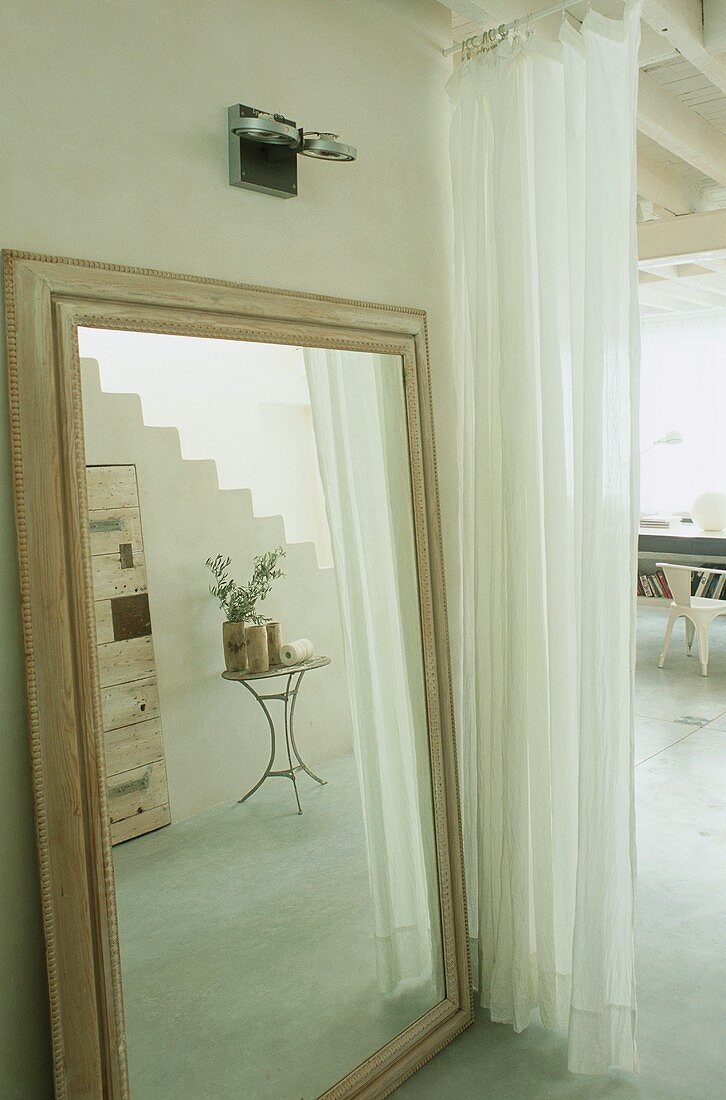 Kleiner Tisch am Treppenaufgang als Spiegelbild in grossem Bodenspiegel