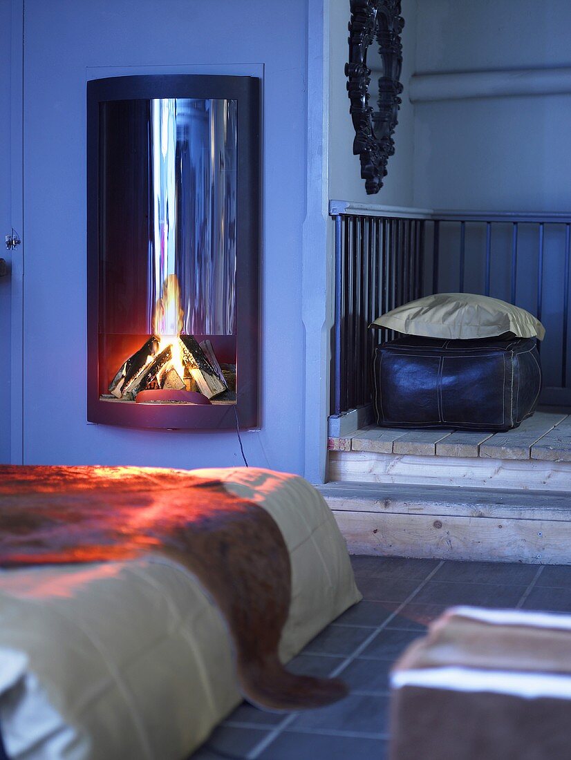Wood burning stove with fire in a country style bedroom