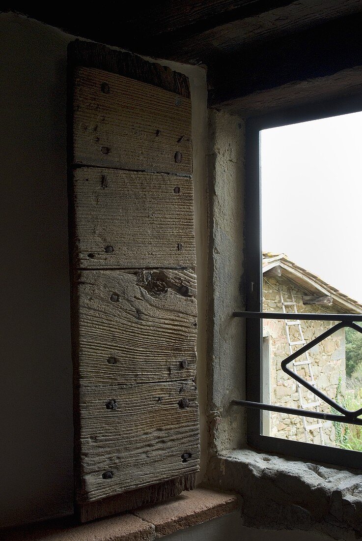 Offene rustikale Fensterladen aus Holz mit Blick nach Aussen