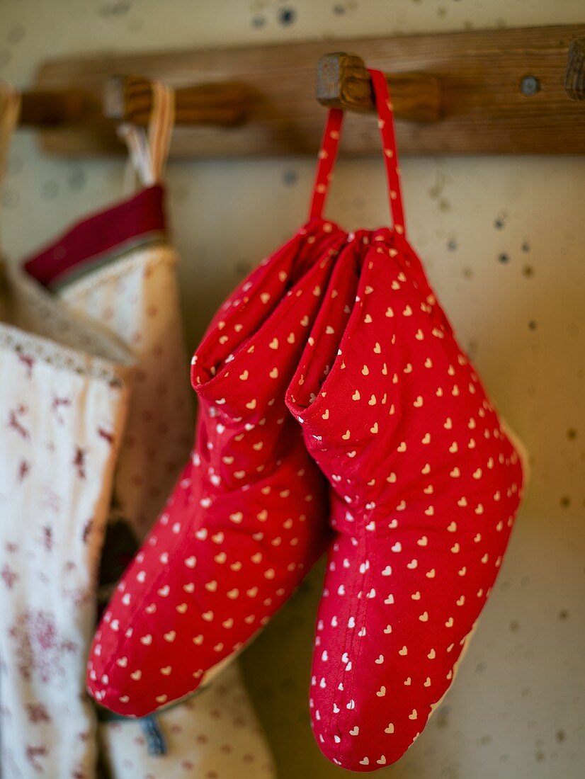 Rote Hausschuhe mit Herzmuster am Garderobenhaken