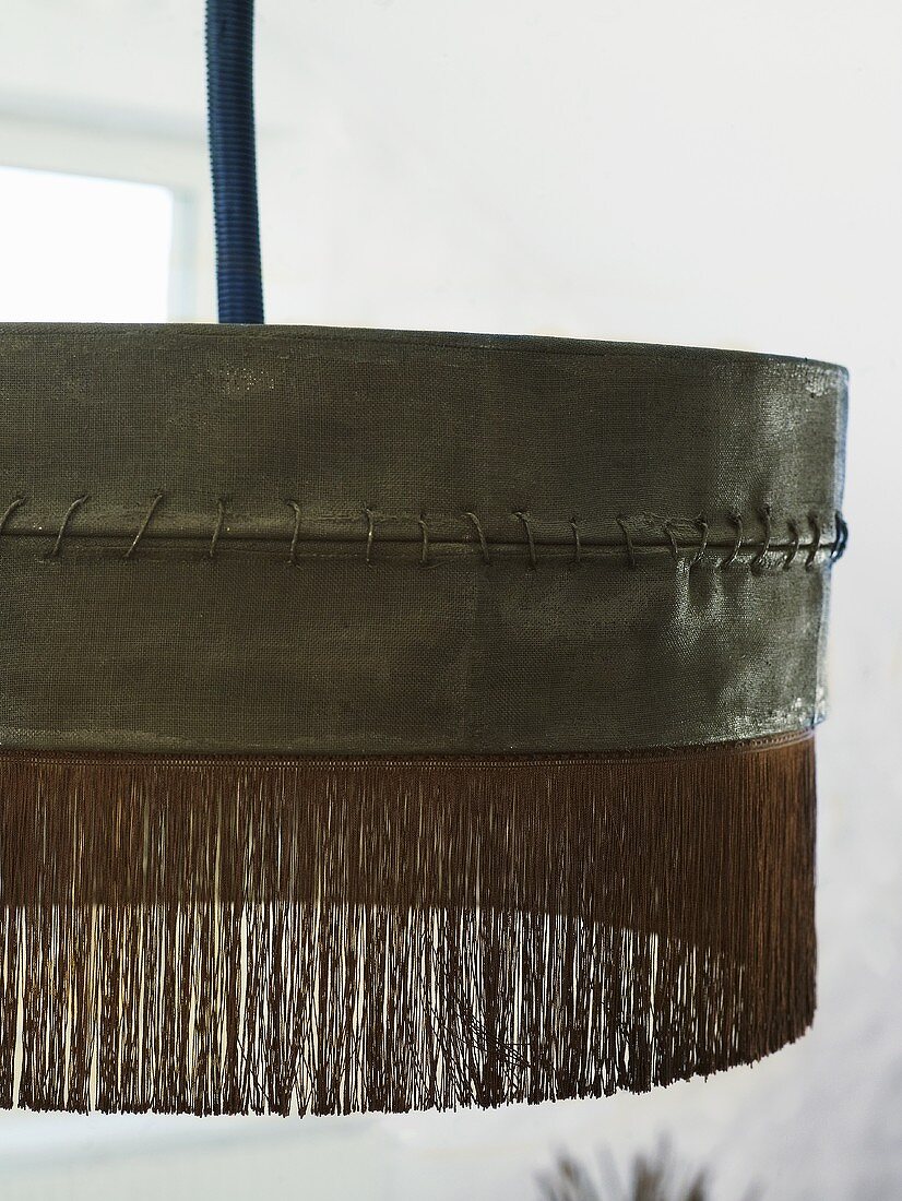 Detail of a black hanging lamp with fringe
