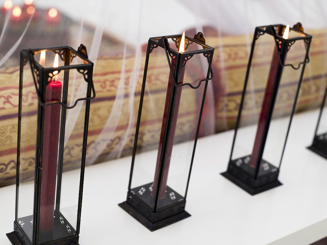 Burning candles in filigree metal stands