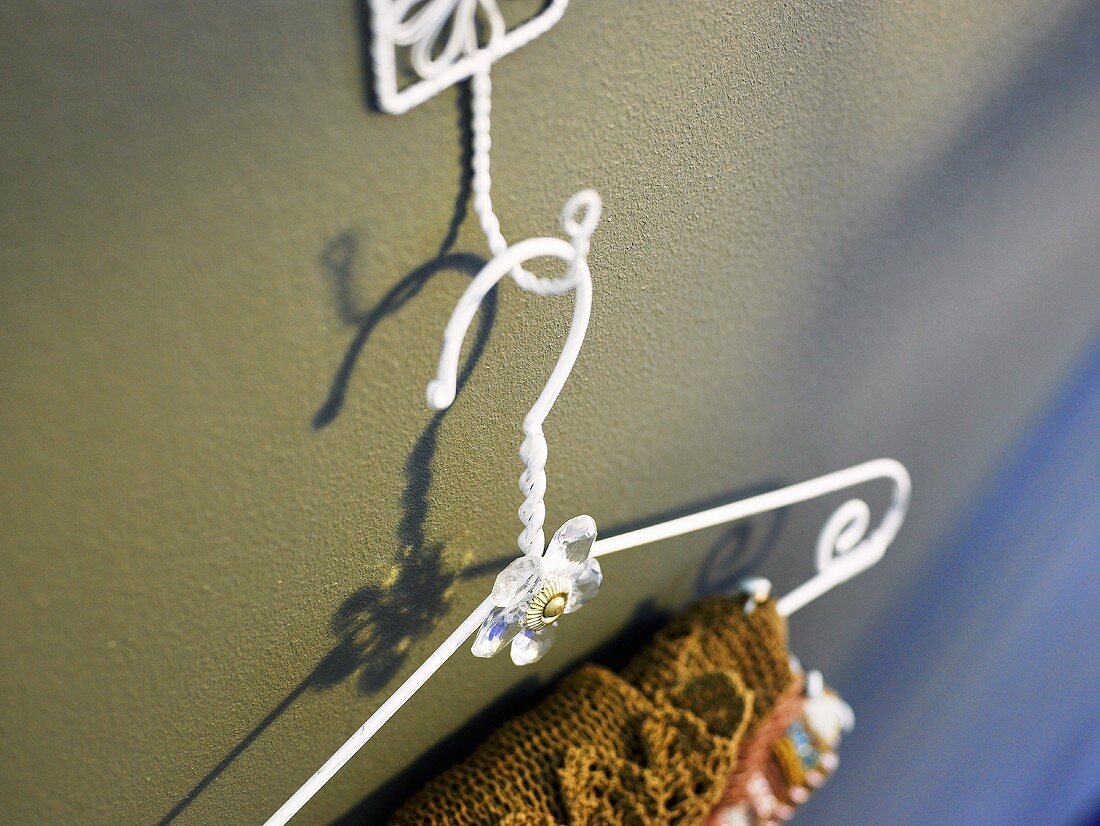 White metal coat hanger on a wall hook