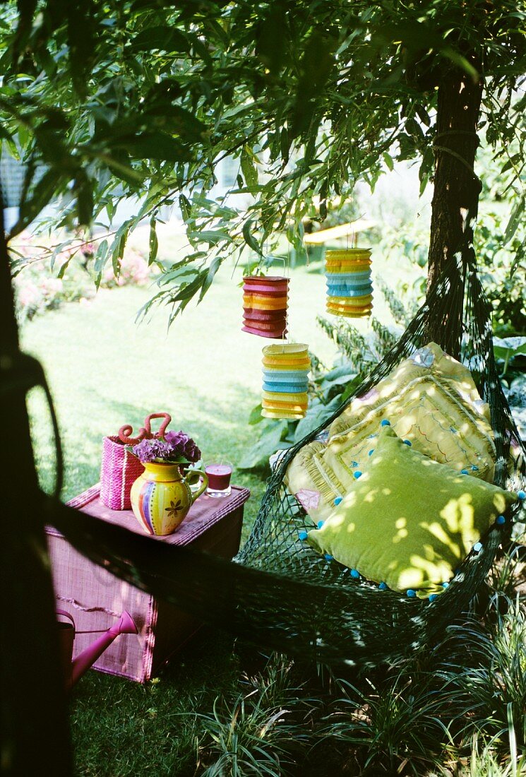 A hammock beneath a tree hung with lanterns